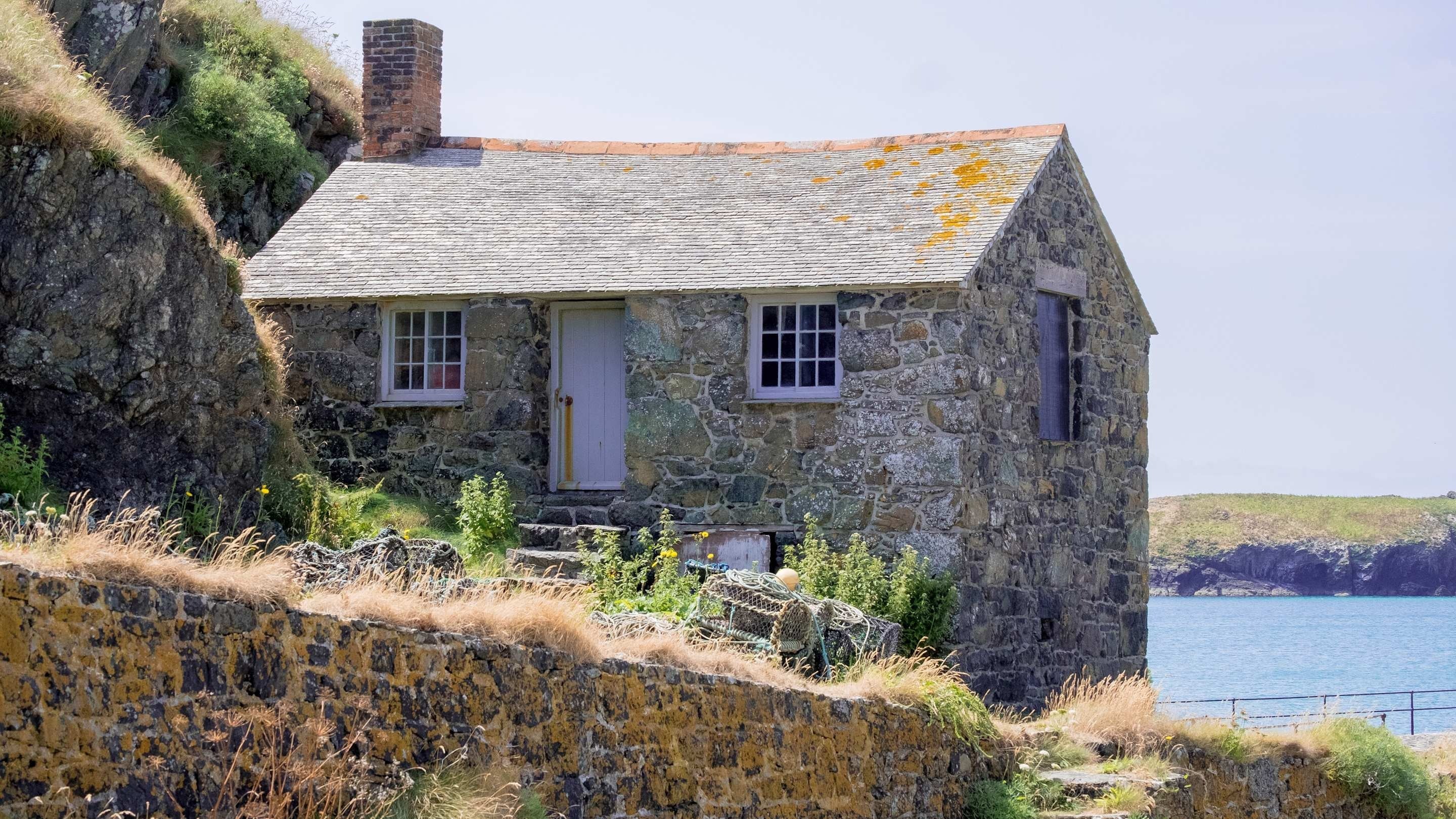 Stone single story seaside cottage with lichen  on roof