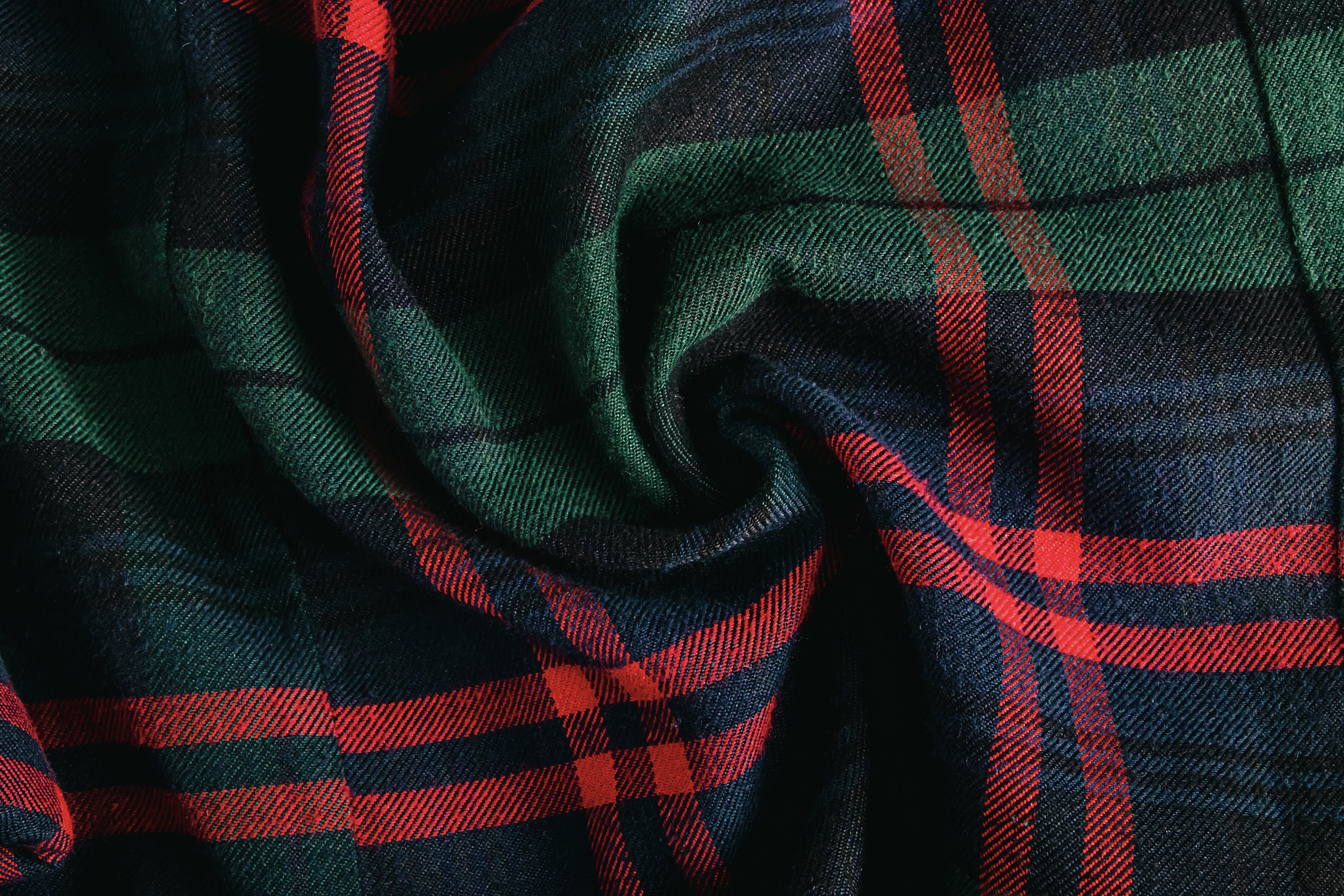 Dark green and red tartan wool fabric softly draped in gentle folds.